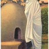 Linen postcard.  White robed Taos Indian.  Bee-hive oven.