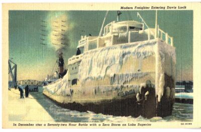 Linen postcard.  Modern Freighter entering Davis Lock, Sault Ste Marie, Michigan.  Zero Storm, Lake Superior.  Ice.  1951.